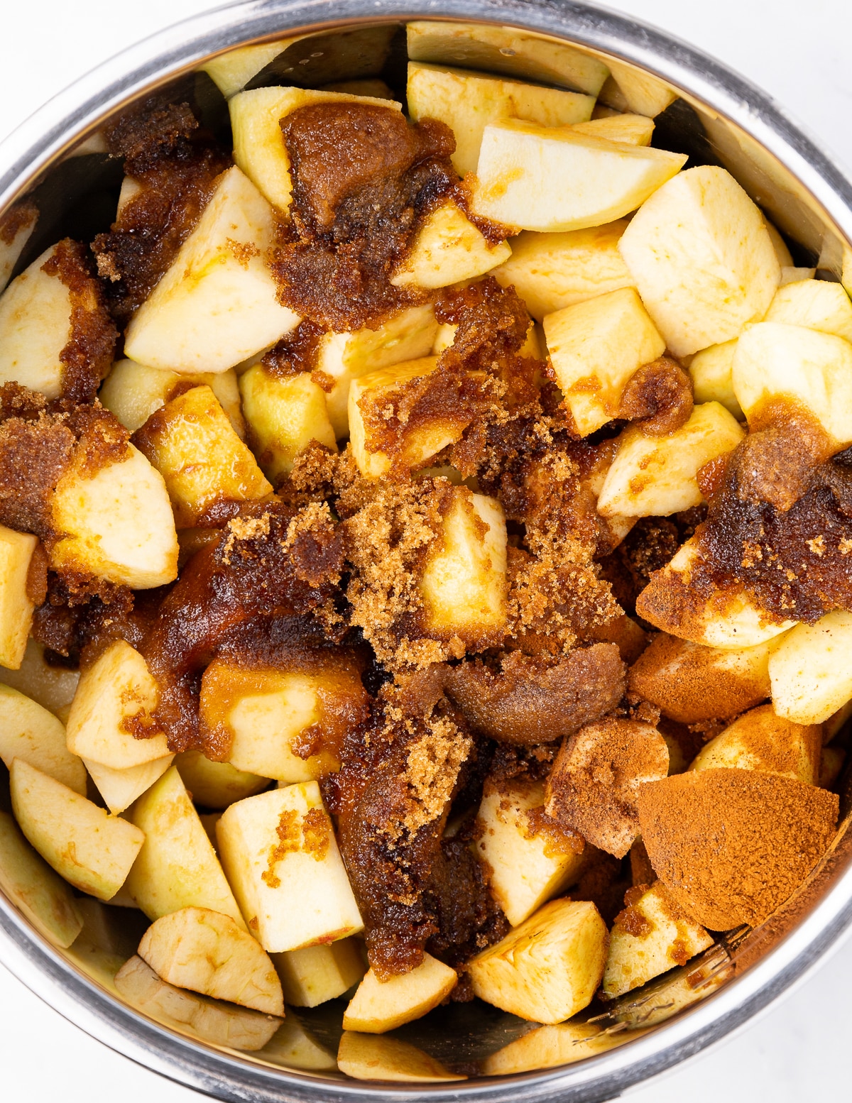 a pan full of raw apples, sugar, and spices