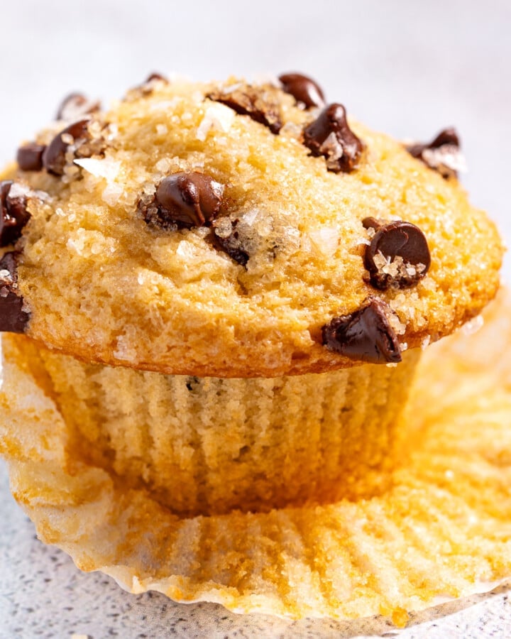 a chocolate chip muffin resting on a muffin liner