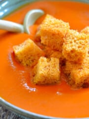 a bowl of vegan tomato soup with golden crouton