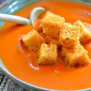 a bowl of vegan tomato soup with golden crouton