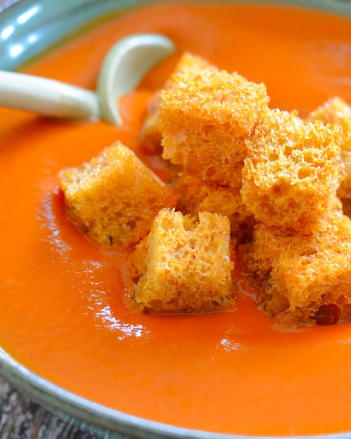 a bowl of vegan tomato soup with golden crouton