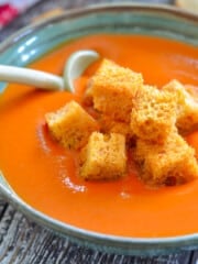 a bowl of vegan tomato soup with croutons