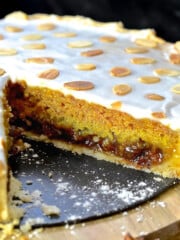 festive mincemeat tart with a big slice removed to show the inside.
