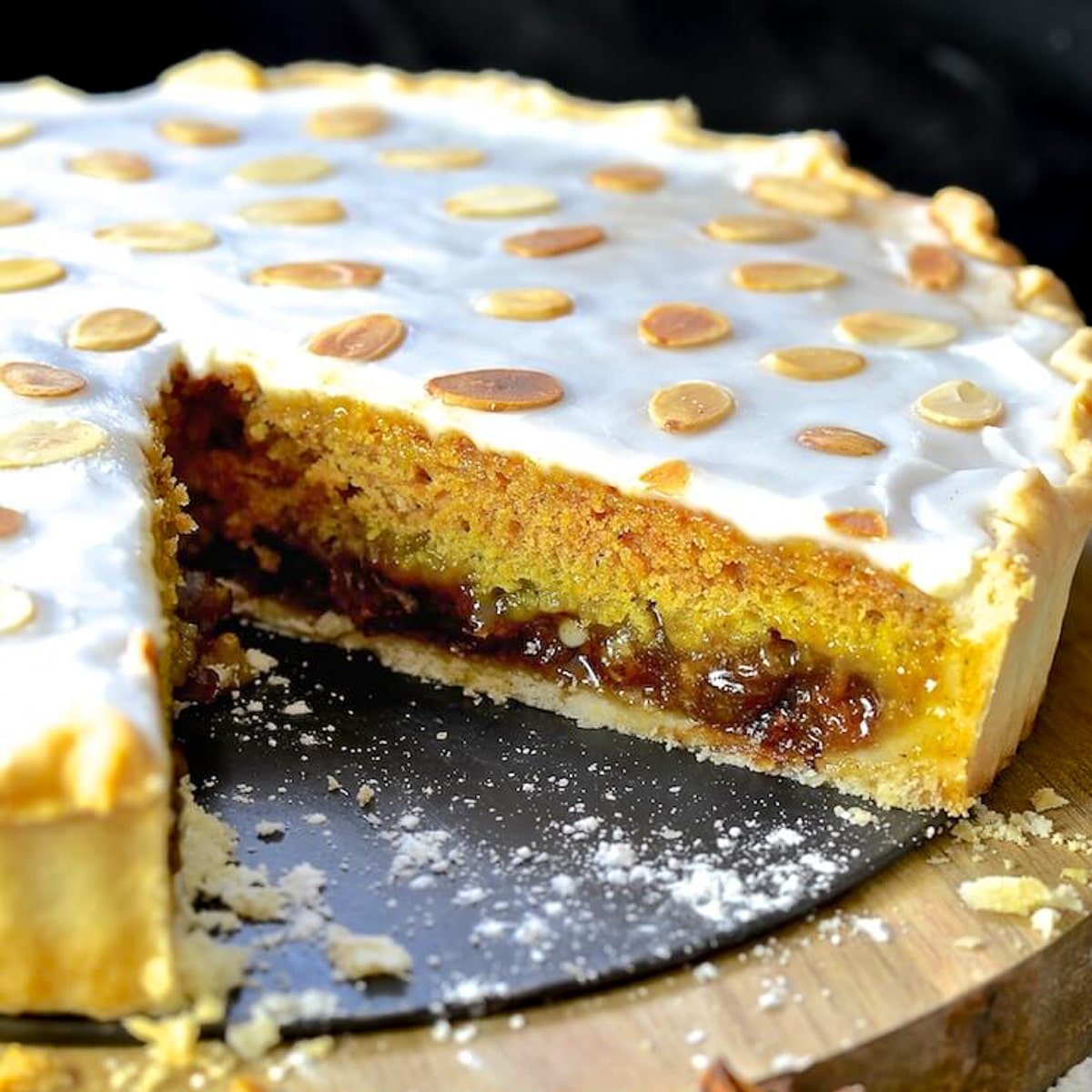 festive mincemeat tart with a big slice removed to show the inside.