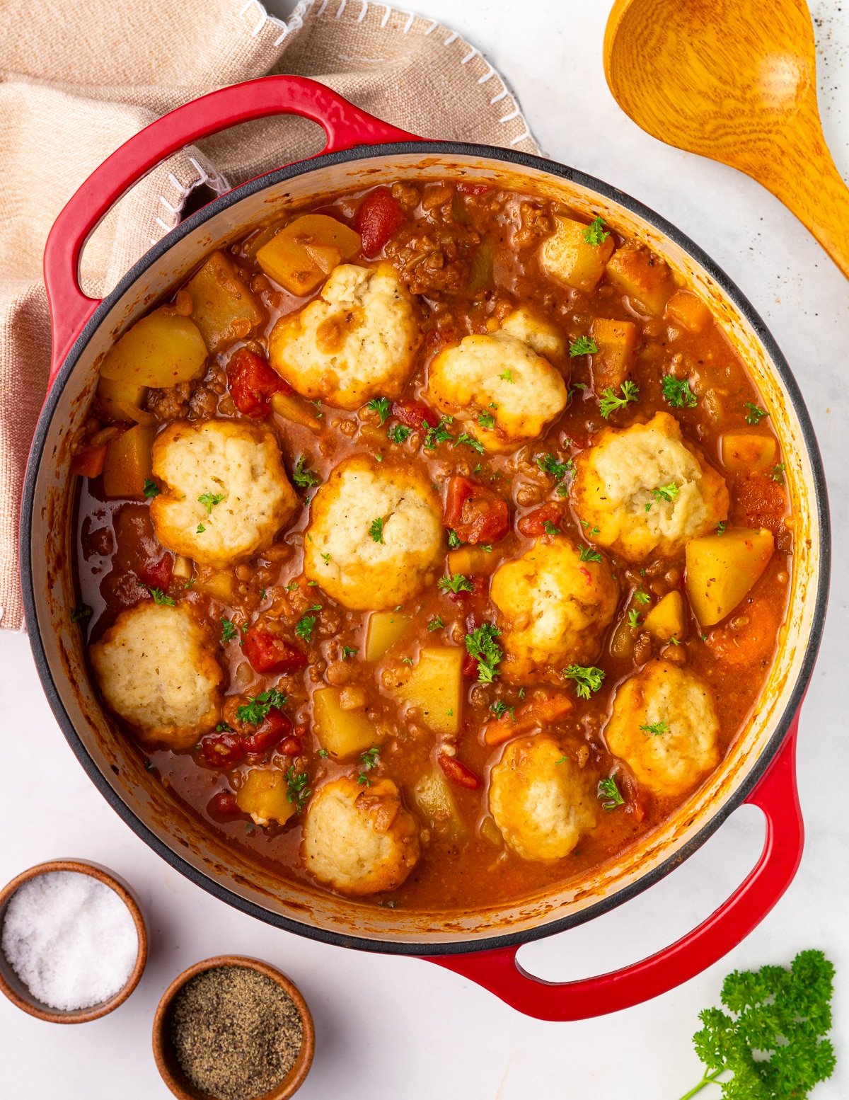  a big pot of stew with dumplings and parsley garnish