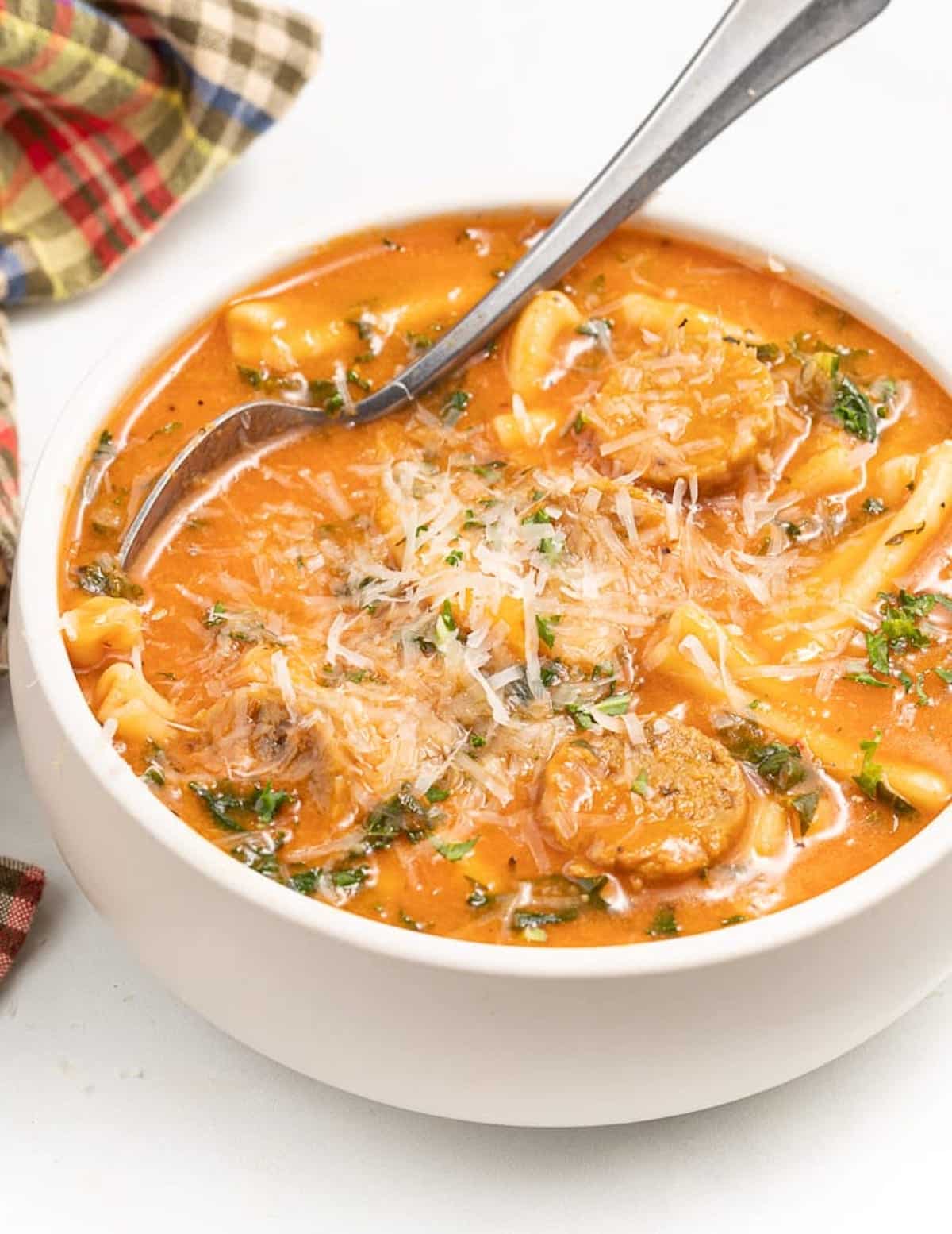a bowl of vegan italian sausage soup with vegan parmesan