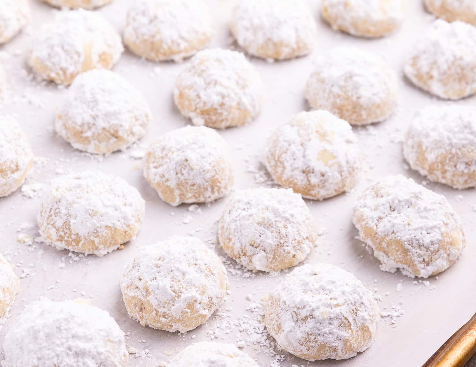 snowball cookies on a parchment line tray