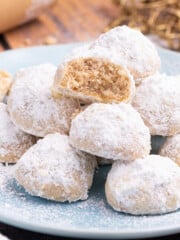 a stack of vegan snowball cookies, one broken in half with the inside showing