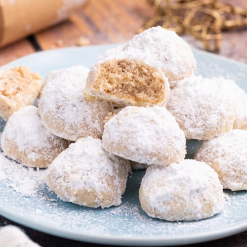 a stack of vegan snowball cookies, one broken in half with the inside showing