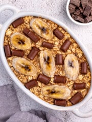 banana bread oatmeal topped with chocolate chunks in a white ceramic dish