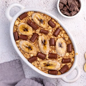 banana bread oatmeal topped with chocolate chunks in a white ceramic dish