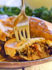 an individual vegan mushroom pie with a slice cut