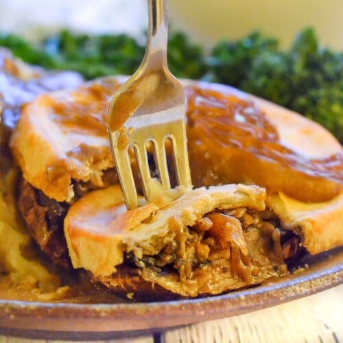 an individual vegan mushroom pie with a slice cut