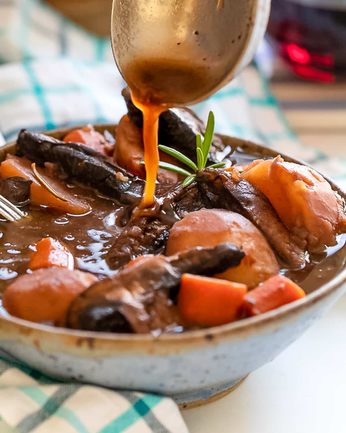 gravy being ladled into a bowl of portobello pot roast