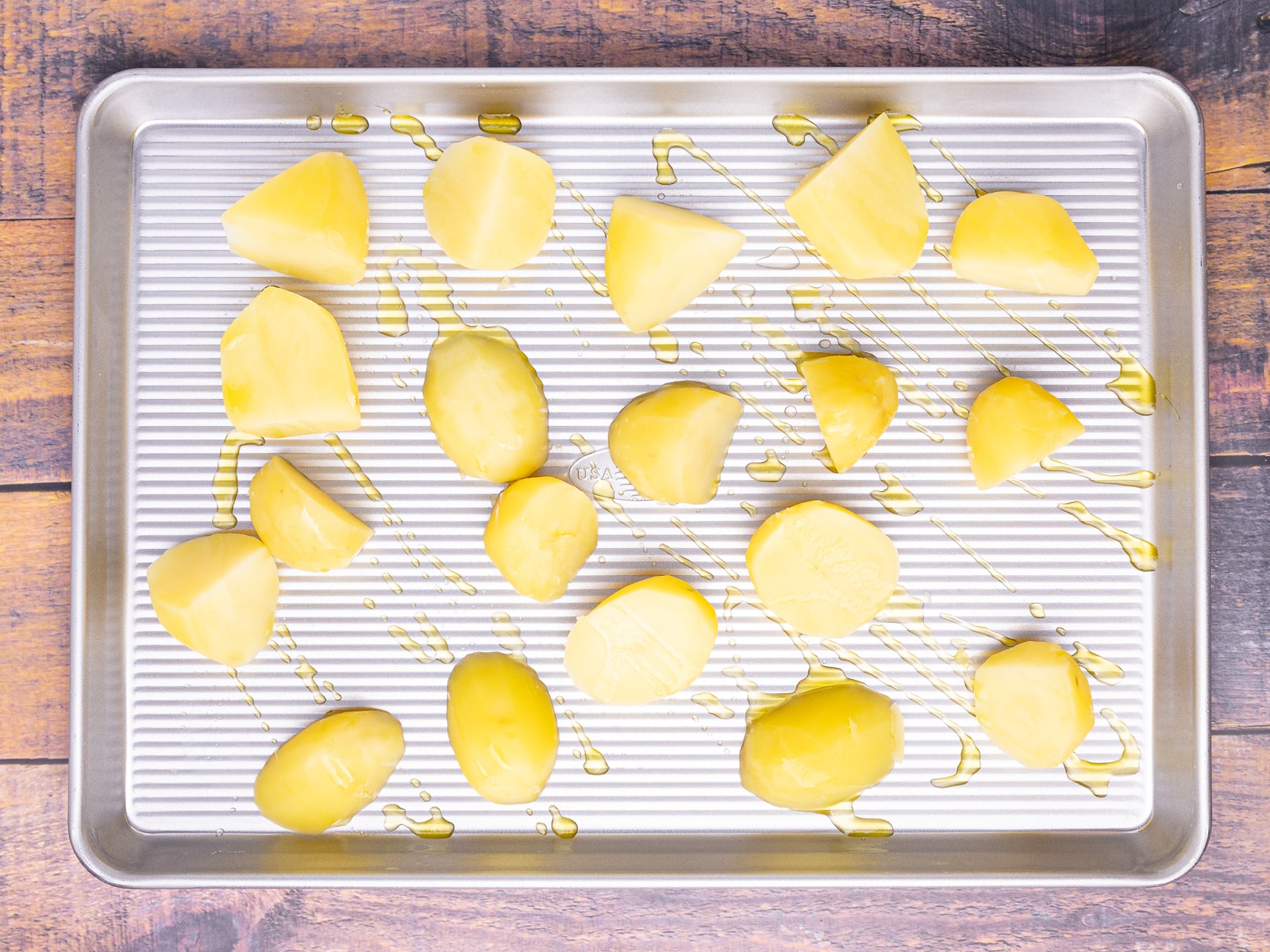 uncooked parboiled potatoes on a baking tray