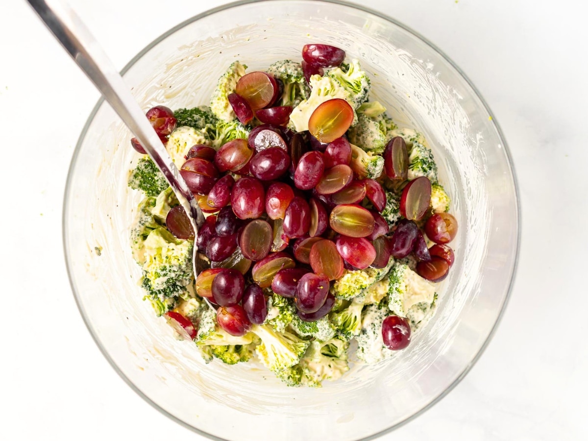 broccoli tossed in a creamy dressing with halved red grapes piled on top