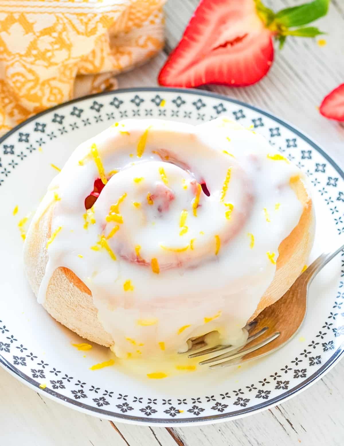 a sticky strawberry lemon sweet roll on a plate