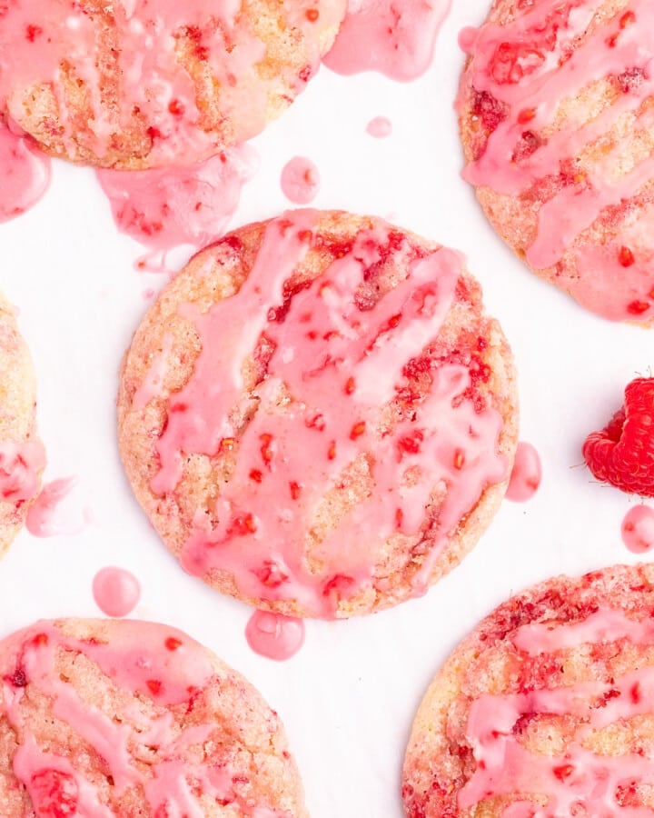 glazed vegan raspberry cookies on a white backdrop, taken from above.