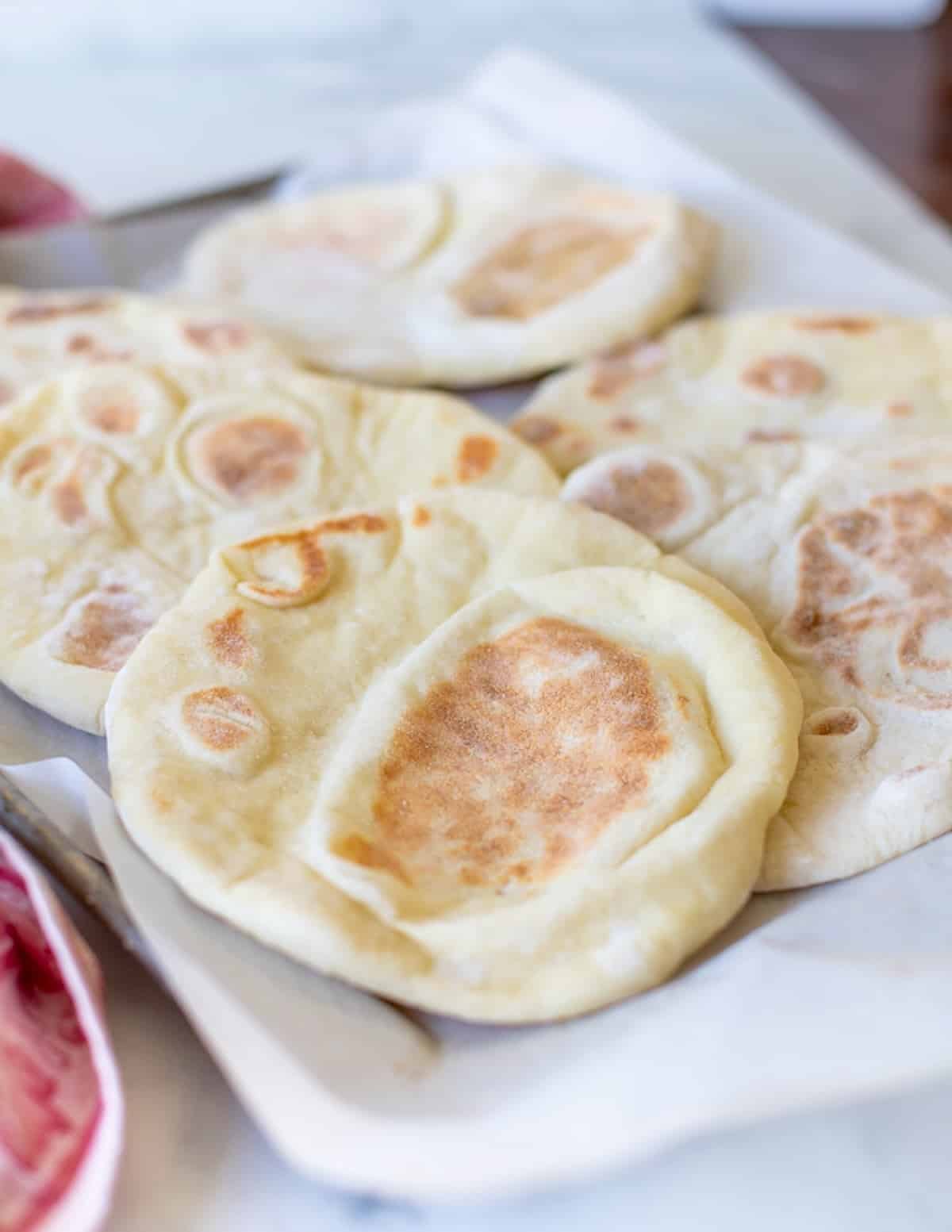 flatbreads on a parchment paper lined baking tray 