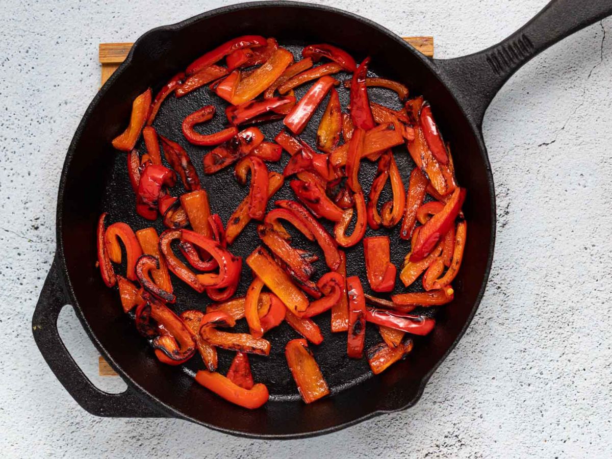 charred red pepper strips in a cast iron skillet