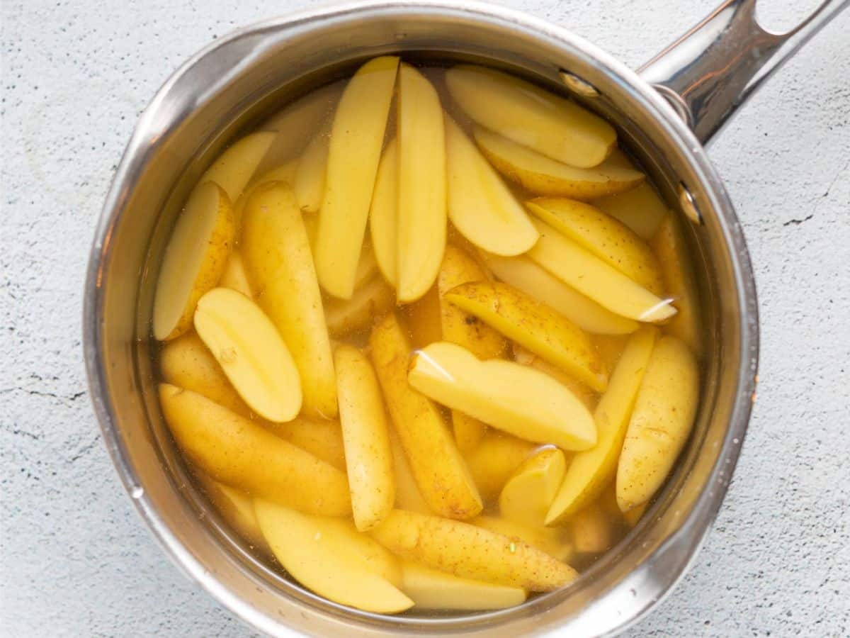 sliced fingerling potatoes in a saucepan of water