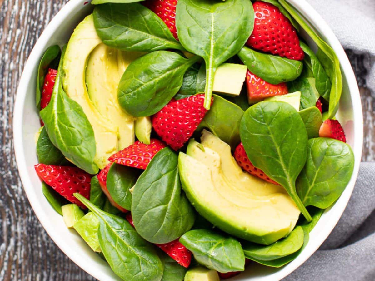 undressed strawberry spinach salad in a bowl