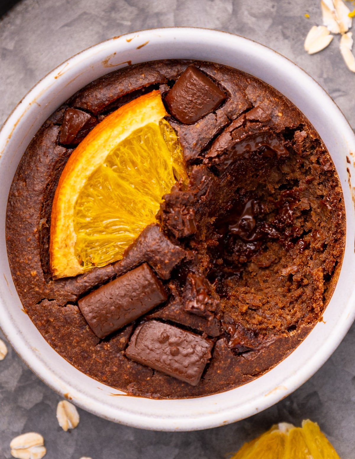 a ramekin of chocolate orange blended baked oats with a spoonful taken out. 