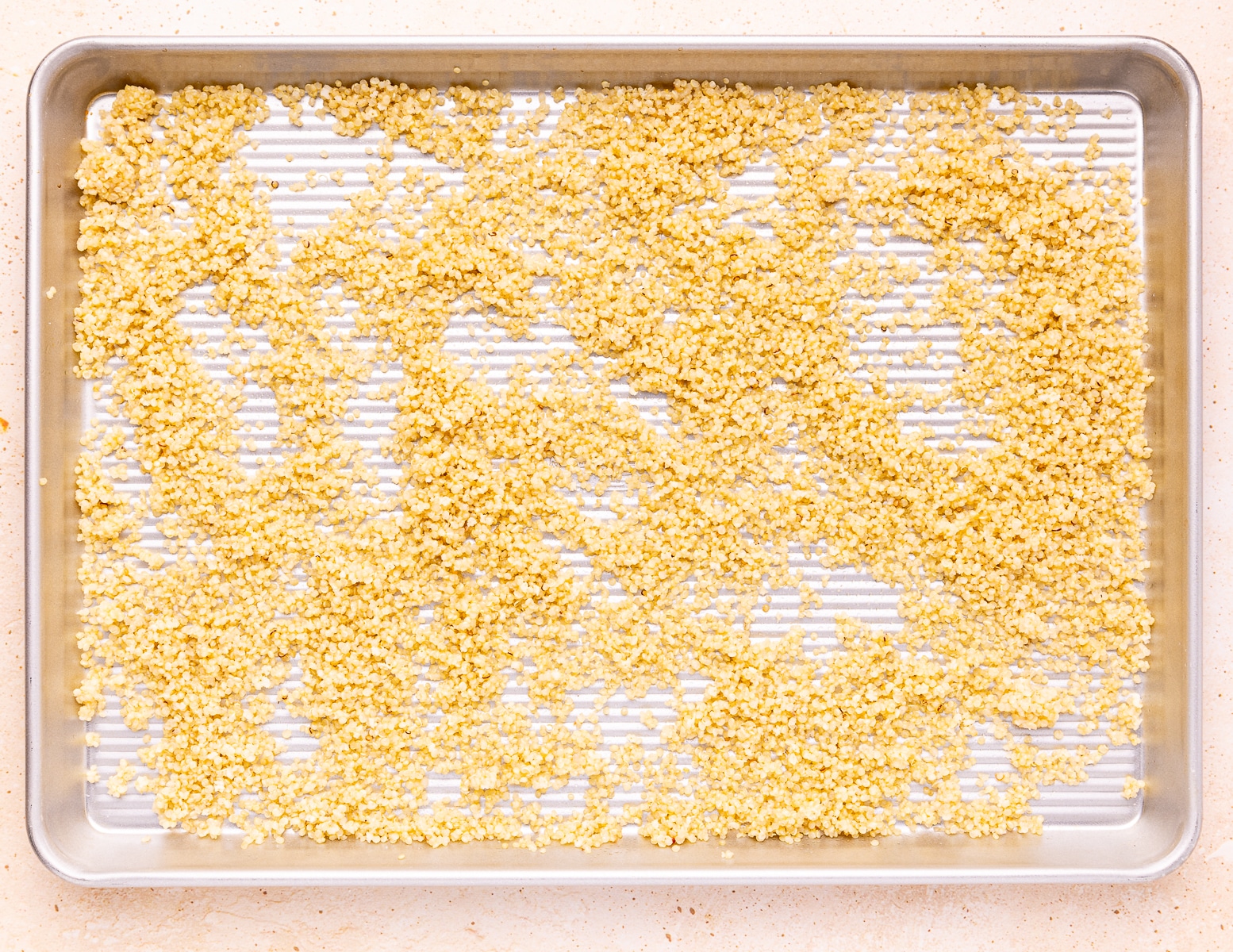 quinoa spread out on a baking tray