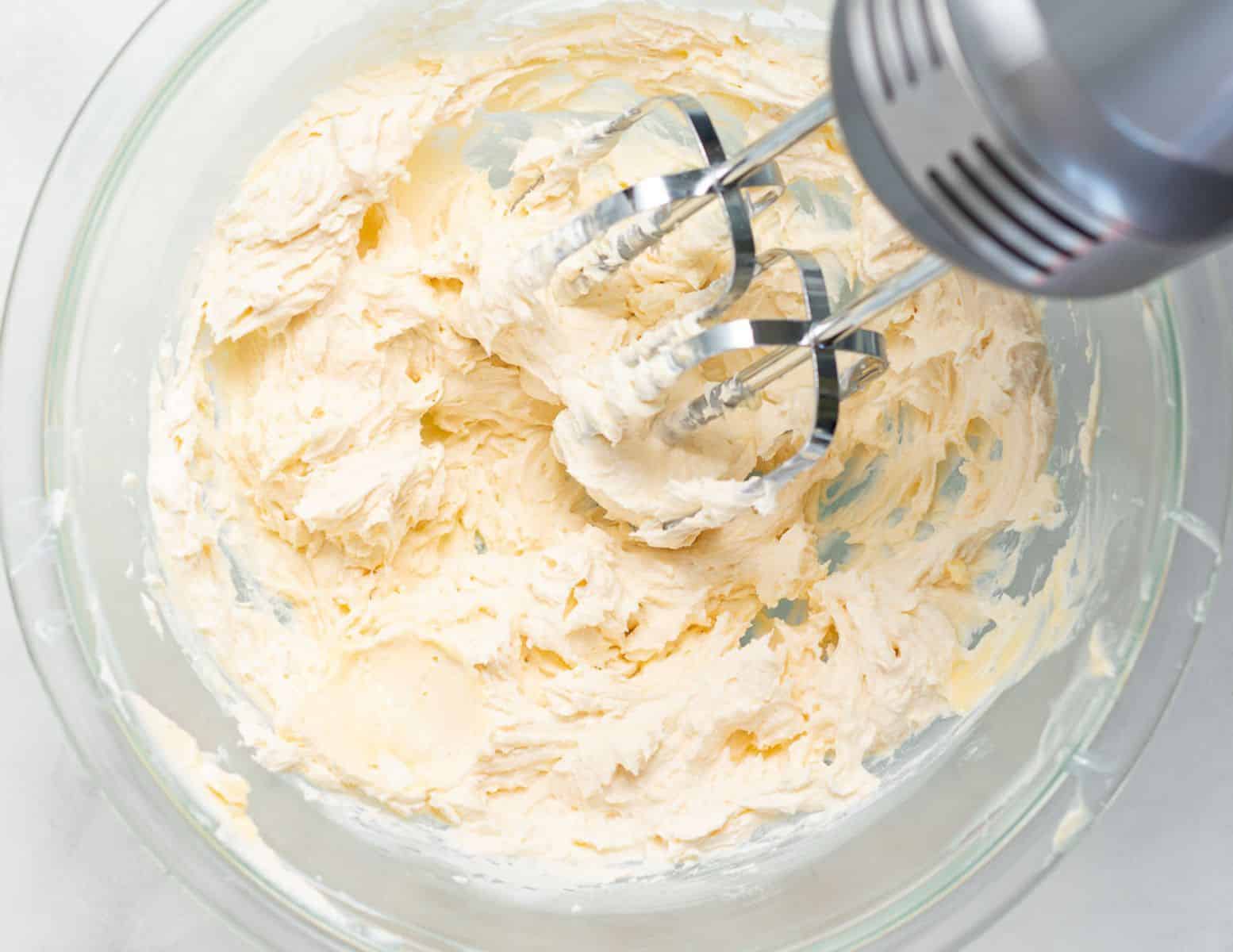 cream cheese frosting being whipped in a bowl. 
