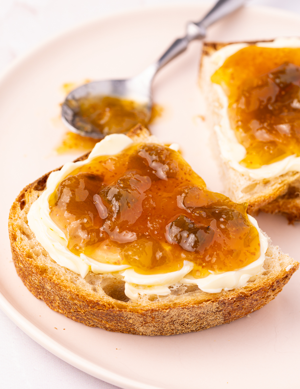 a slice of bread spread with vegan butter and fig jam