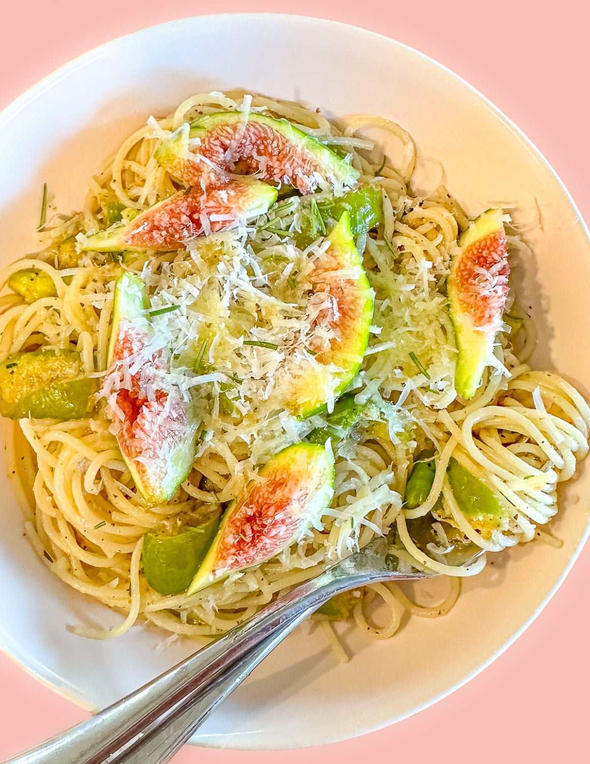 a bowl of fig pasta with lots of vegan Parmesan cheese.