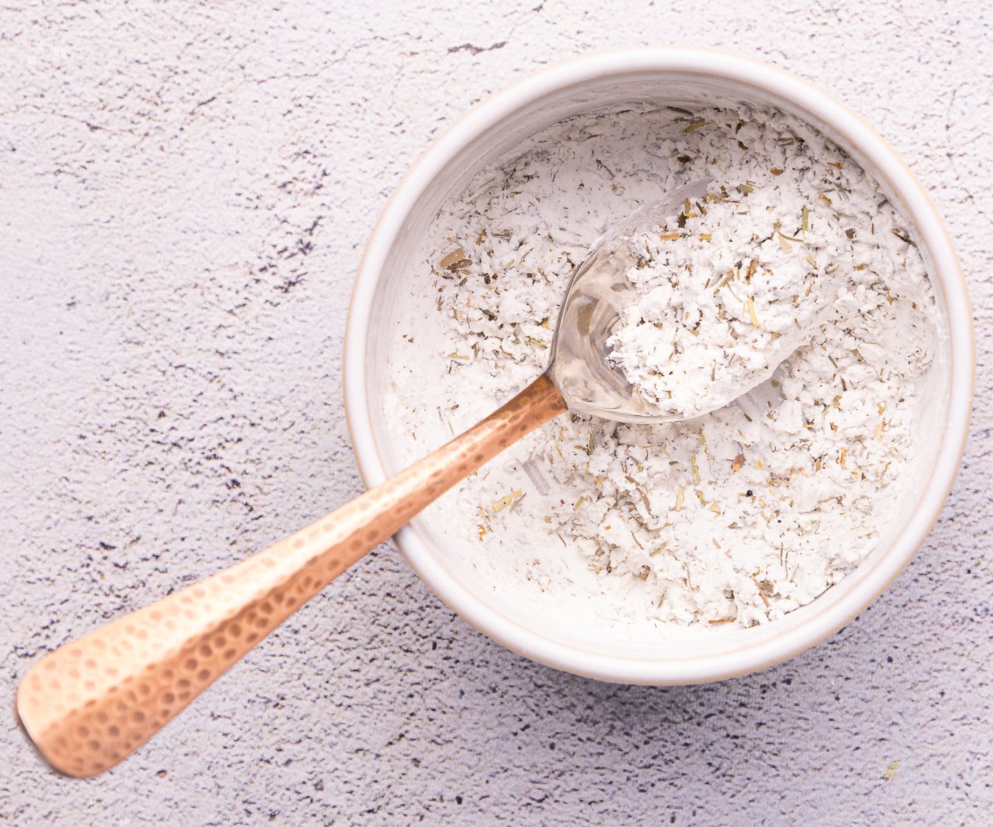 a small bowl of cornstarch mixed with herbs and seasonings. 