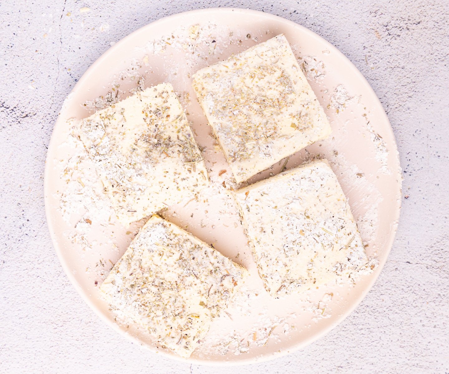 4 squares of tofu coated in herby cornstarch mixture. 