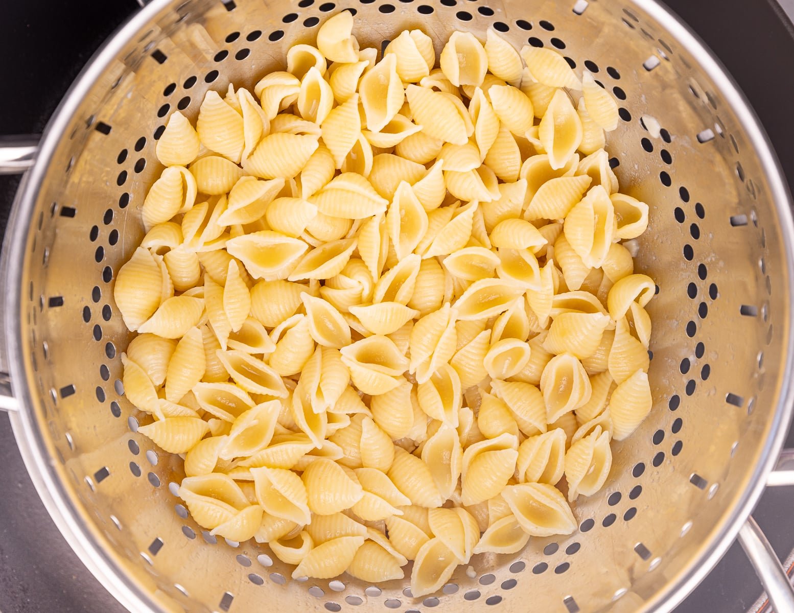 cooked mini pasta shells in a colander. 