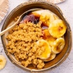 a rustic bowl filled with yogurt, buttery cookie crumbs, sliced banana, and vegan honey drizzles.