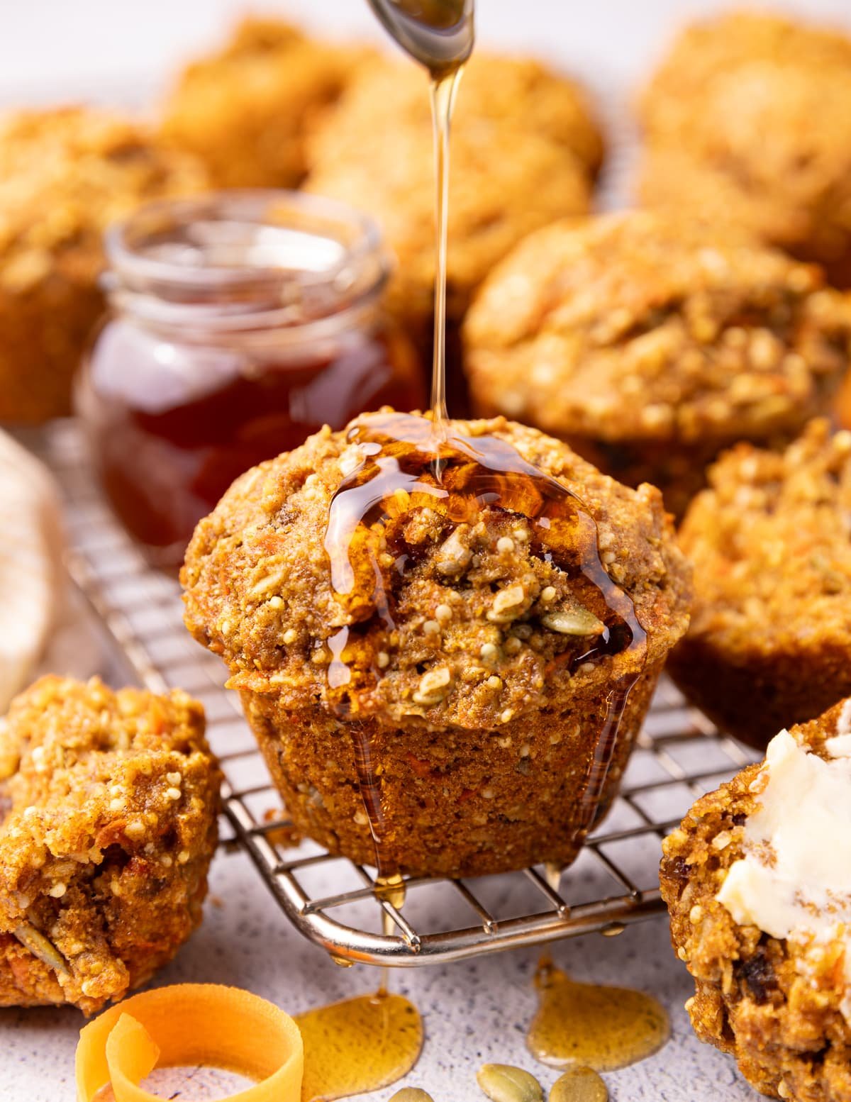 A vegan morning glory muffin being drizzled with vegan honey.