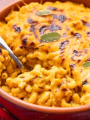 cheesy, saucy, vegan pumpkin mac and cheese in a terracotta dish.