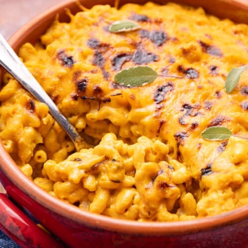 cheesy, saucy, vegan pumpkin mac and cheese in a terracotta dish.