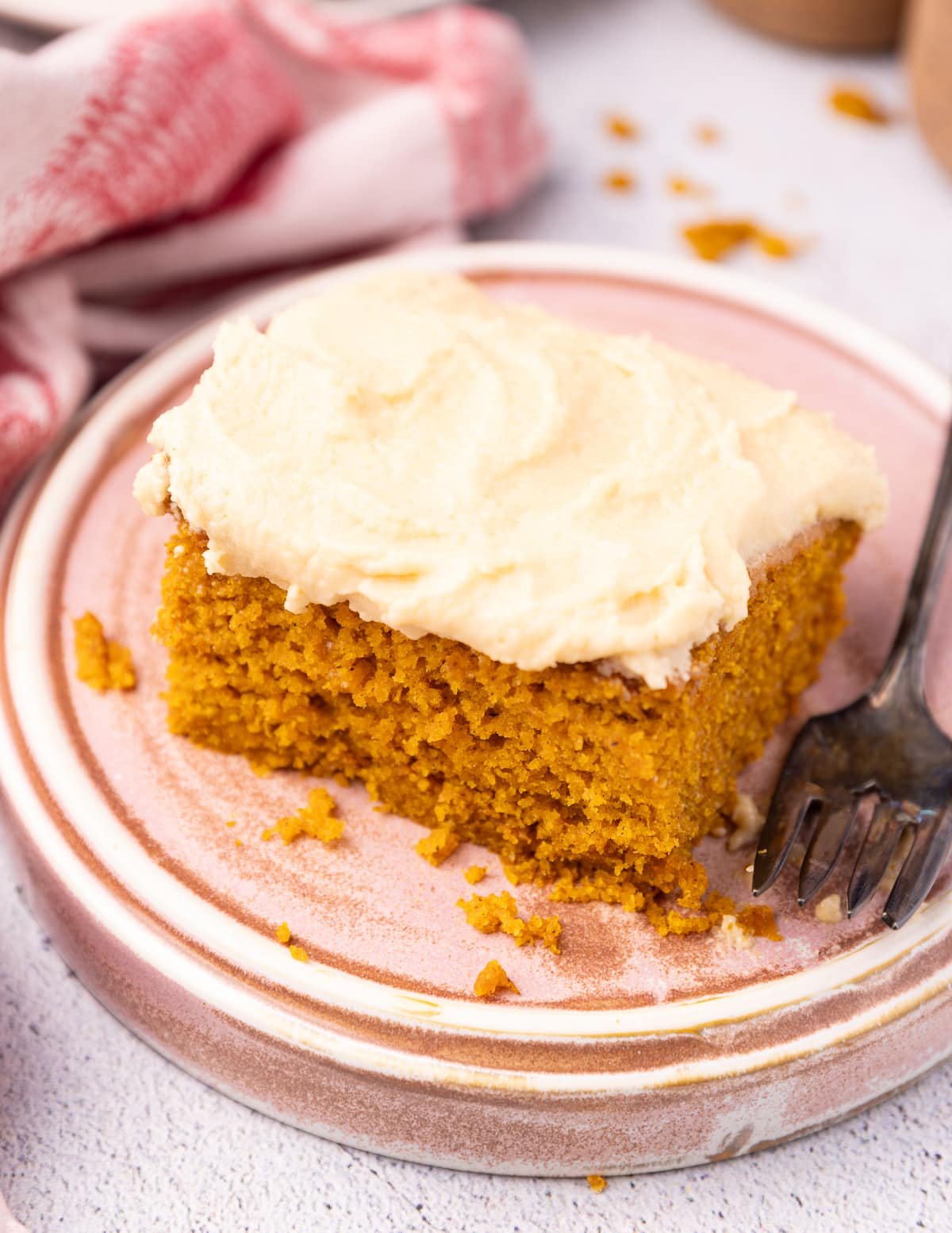 a slice of vegan pumpkin cake on a pink plate