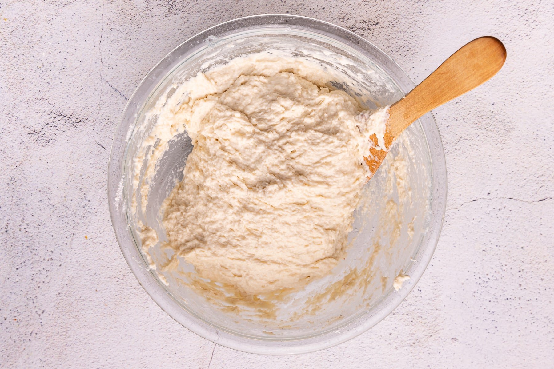 shaggy wet dough in a bowl with a wooden spatula