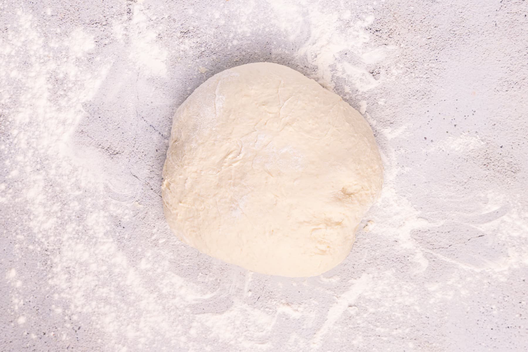 a ball of bread dough on a floured surface