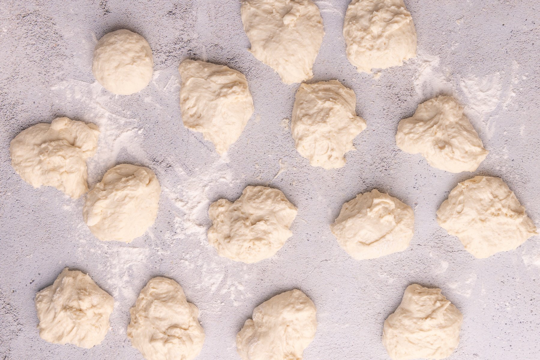 pieces of wet looking dough on a floured surface