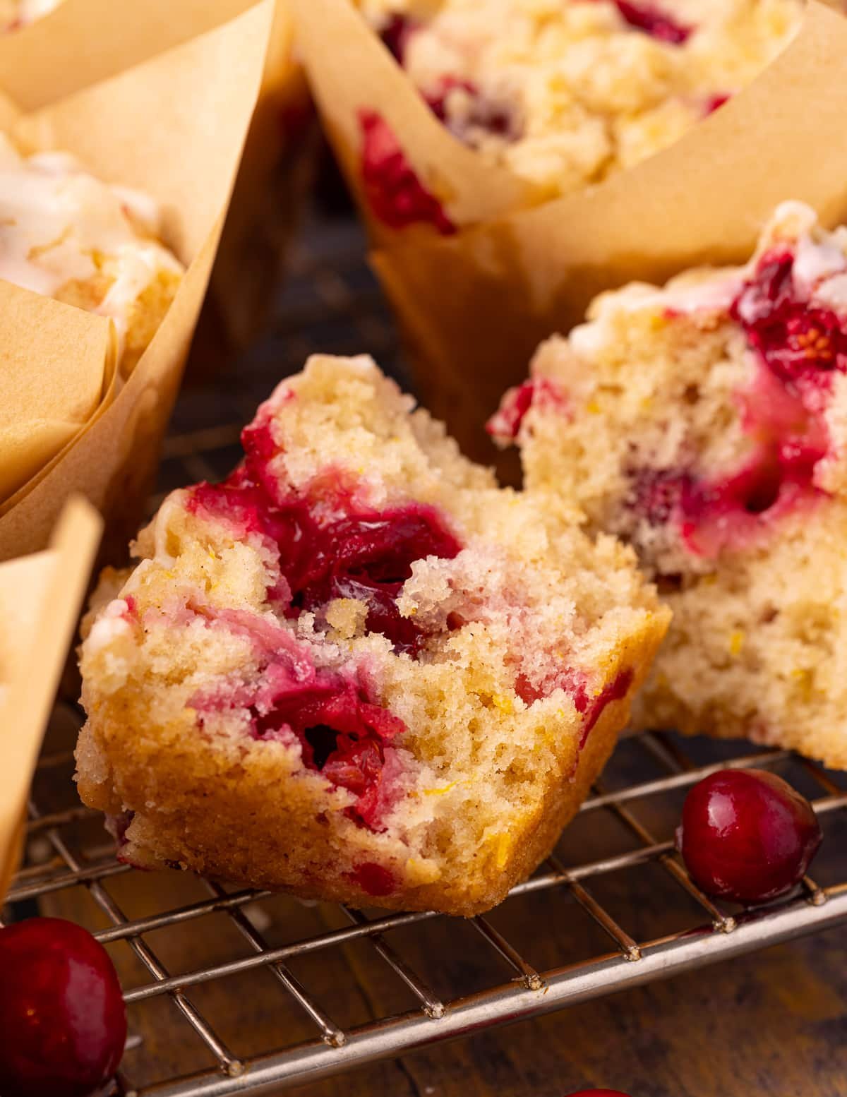 half of a vegan cranberry orange muffin with the jammy cranberry insides showing