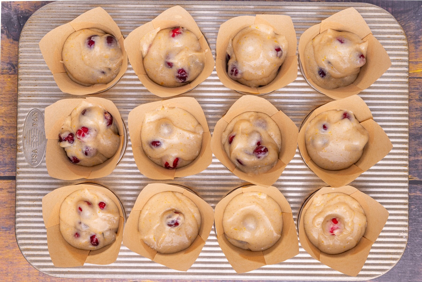 muffin batter in tulip muffin liners in a muffin pan