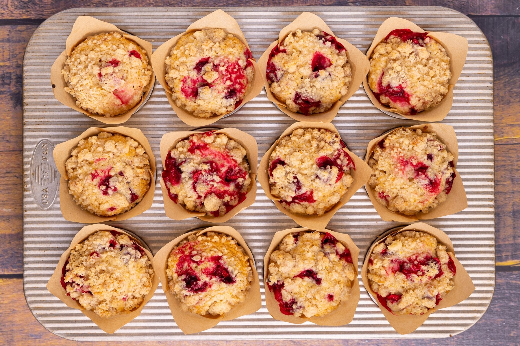 jammy and sticky looking cranberry orange muffins in a muffin pan