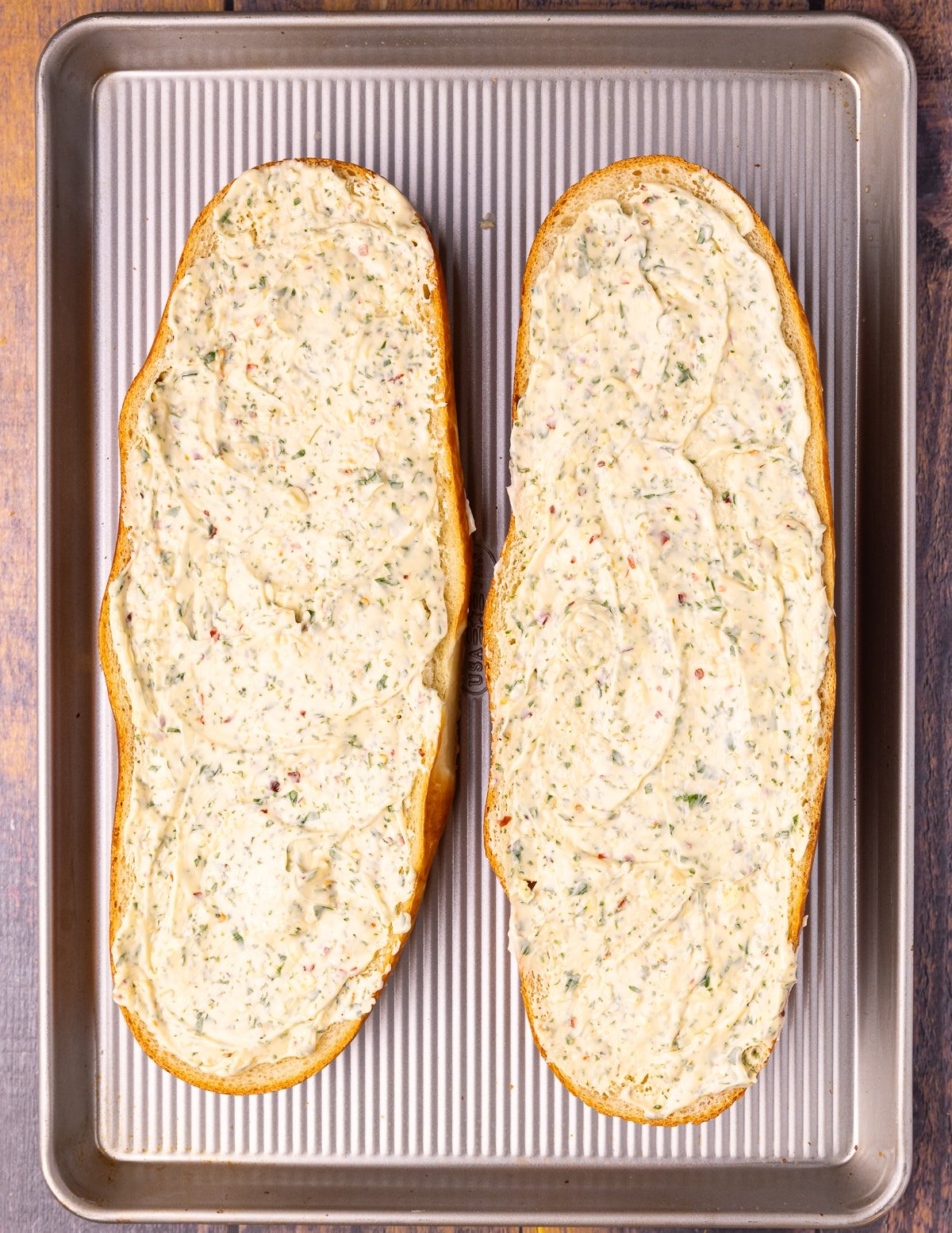 2 pieces of uncooked garlic bread on a baking tray