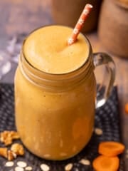 a glass of carrot cake smoothie with an orange straw