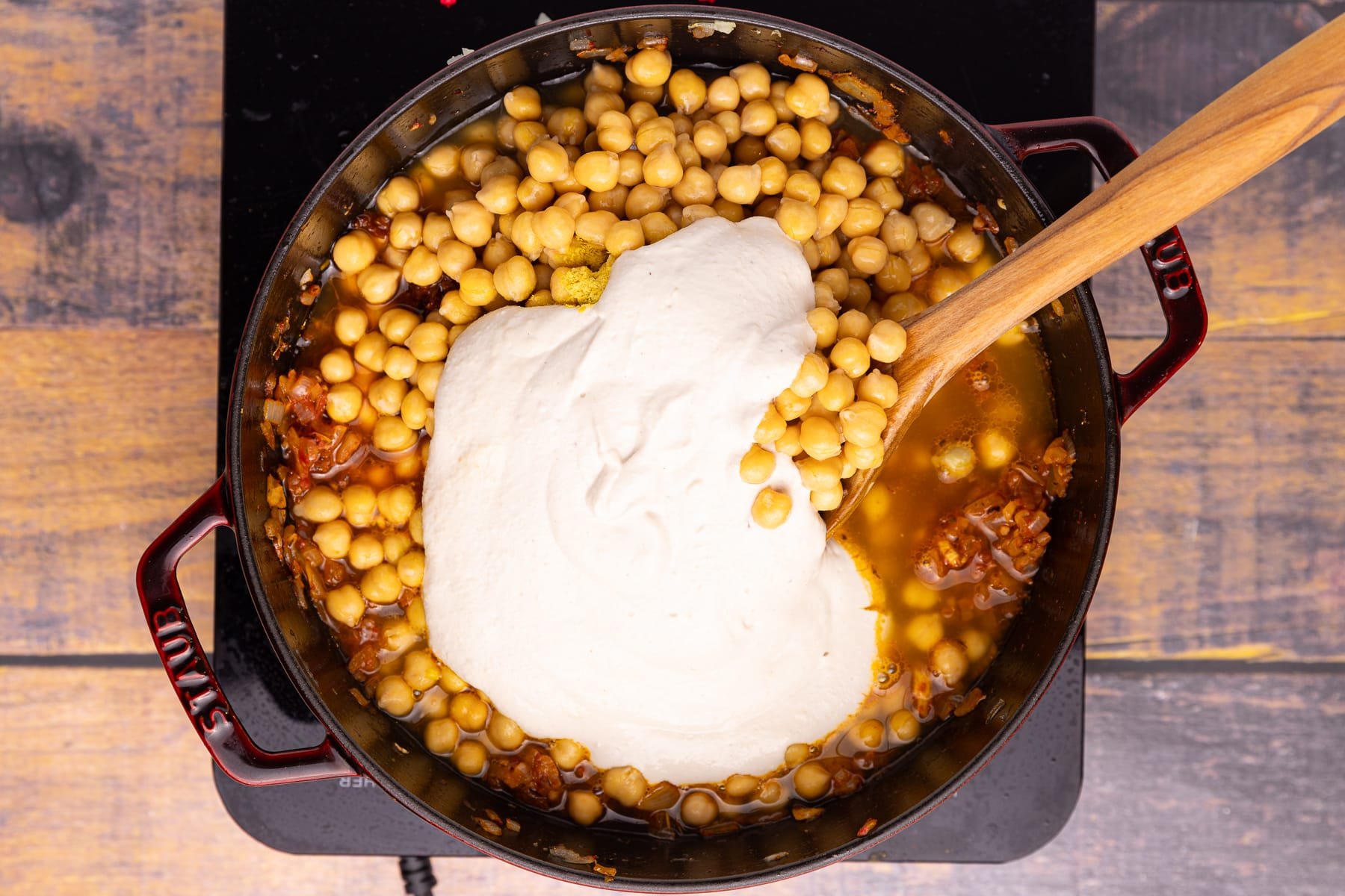 chickpeas, onions, garlic, tomato puree, and cashew cream in a skillet