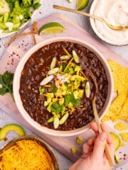 a bowl of black bean soup with toppings