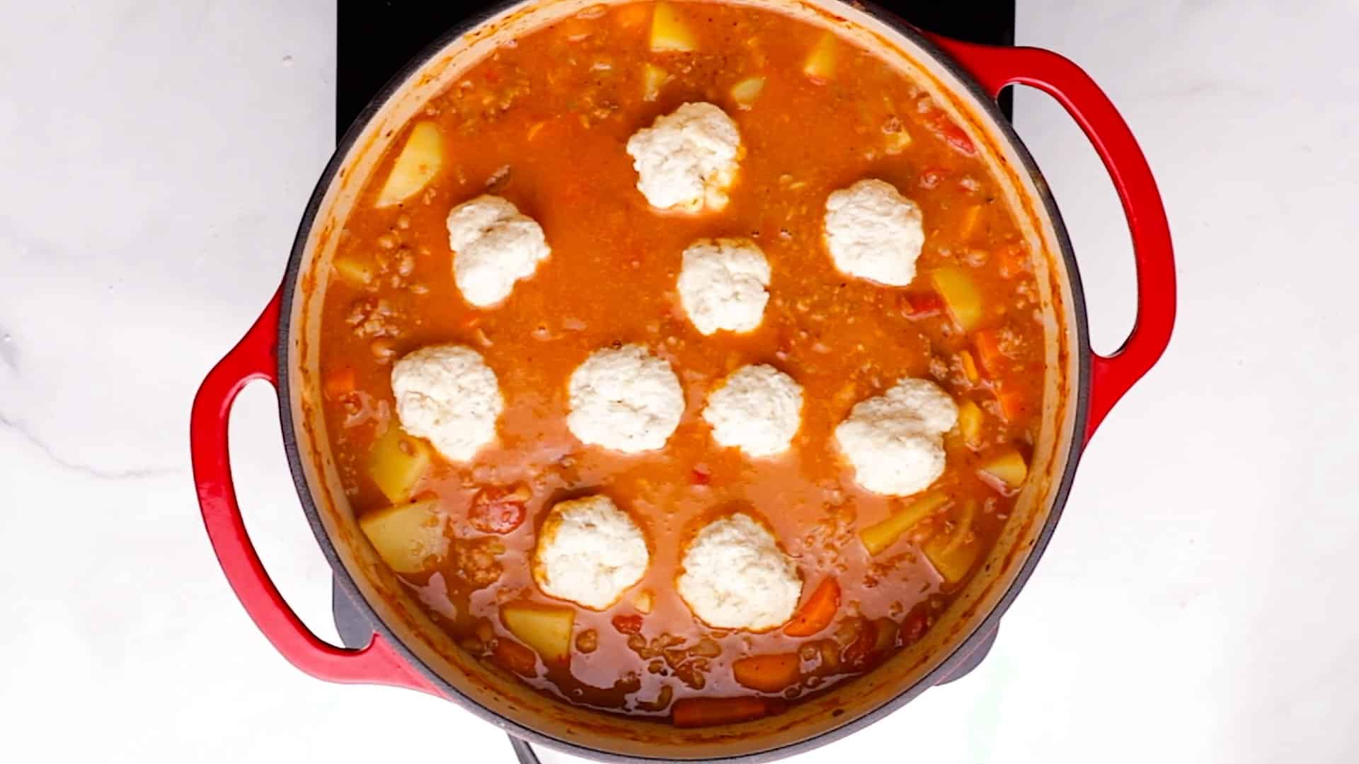 uncooked dumplings floating on some stew